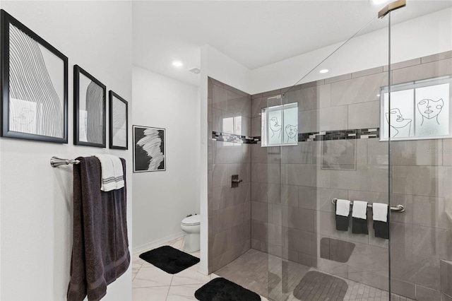 bathroom with toilet and a tile shower