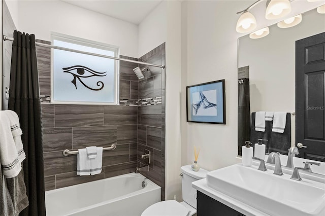 full bathroom with tiled shower / bath, vanity, and toilet