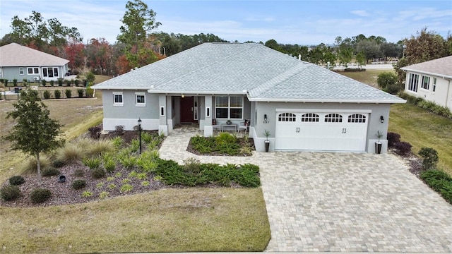 ranch-style house featuring a garage, covered porch, and a front yard