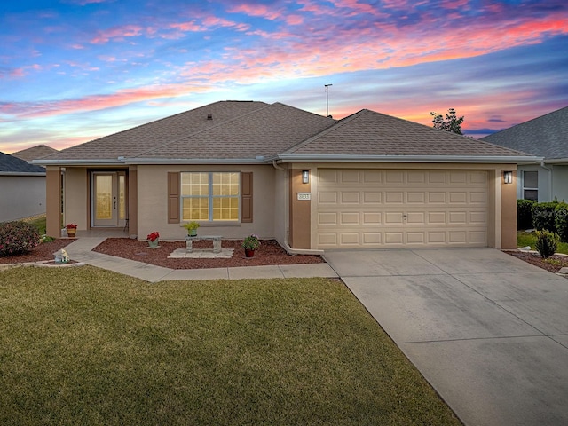 view of front of house with a garage and a yard