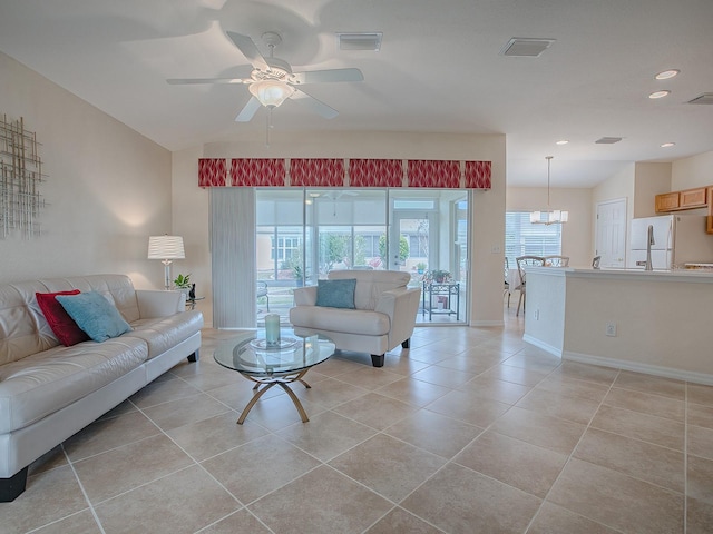 living room featuring ceiling fan with notable chandelier and lofted ceiling