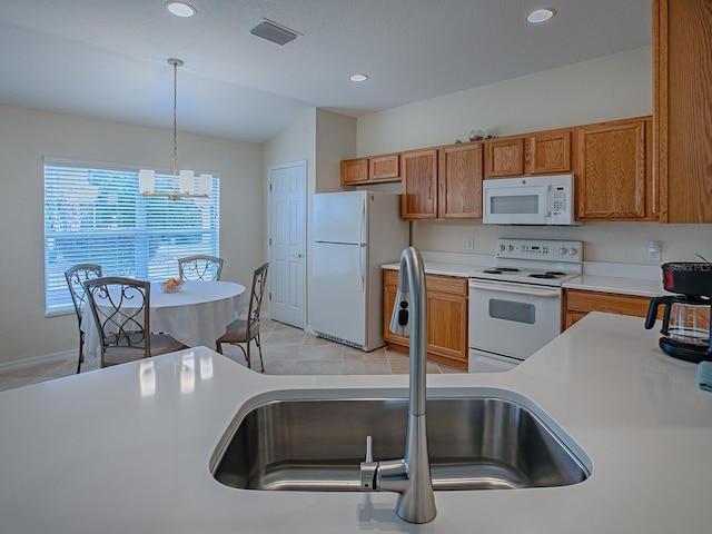 kitchen with decorative light fixtures, lofted ceiling, light tile patterned flooring, sink, and white appliances