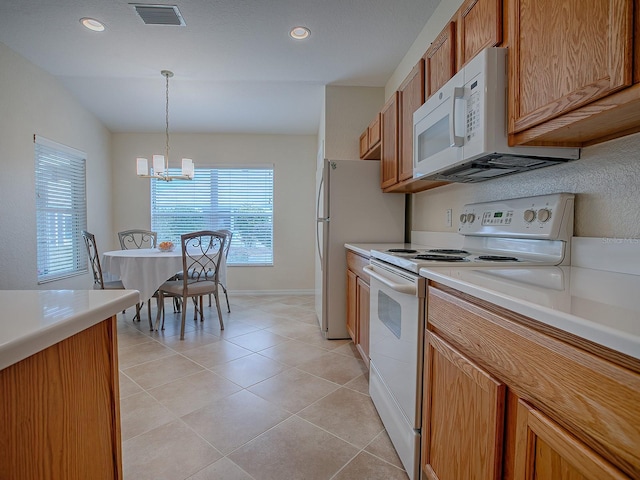 kitchen featuring light tile patterned flooring, a chandelier, hanging light fixtures, and white appliances