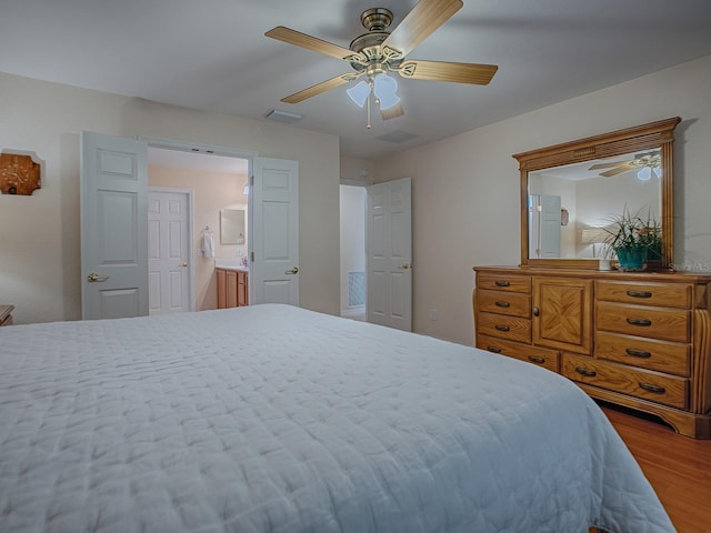 bedroom featuring ceiling fan, connected bathroom, and hardwood / wood-style flooring