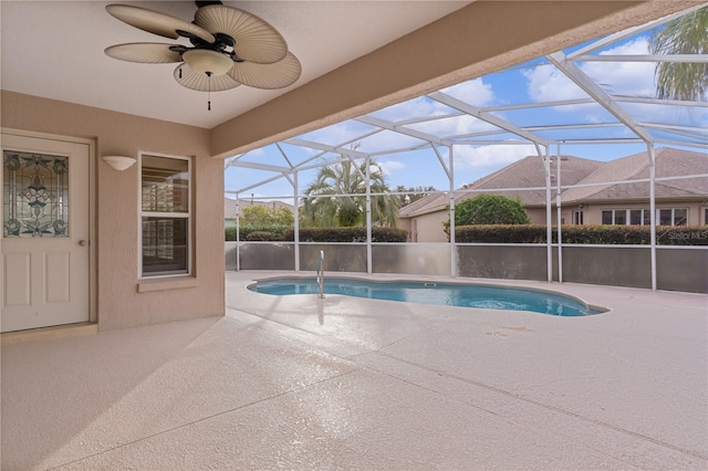 view of swimming pool with a patio, a lanai, and ceiling fan