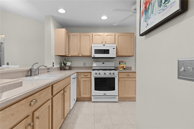 kitchen featuring light brown cabinetry, sink, white appliances, and light tile patterned floors