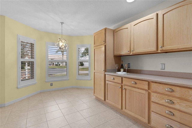 kitchen featuring light tile patterned floors, hanging light fixtures, and light brown cabinets