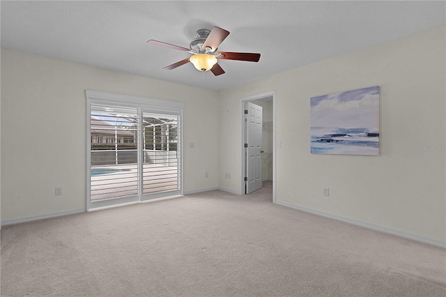 carpeted empty room featuring ceiling fan