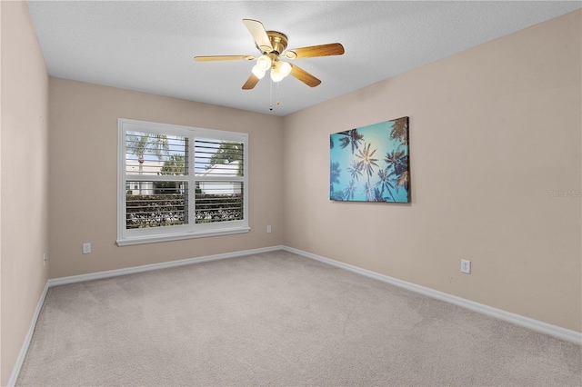 carpeted spare room featuring a textured ceiling and ceiling fan