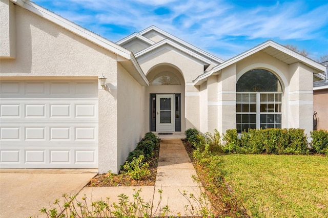 property entrance featuring a garage and a yard