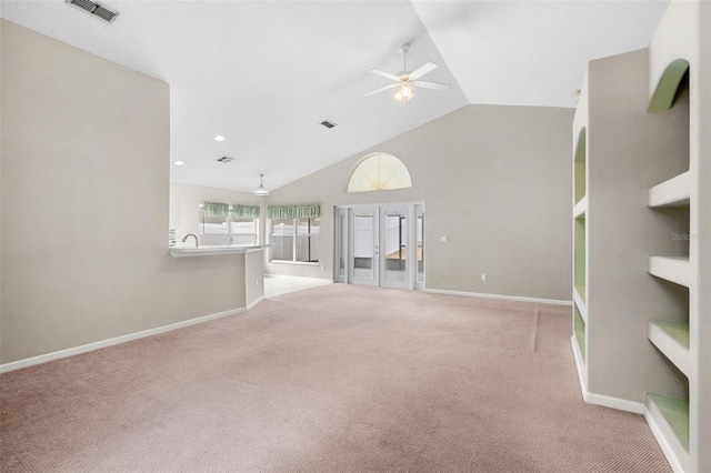 unfurnished living room featuring ceiling fan, lofted ceiling, and light carpet