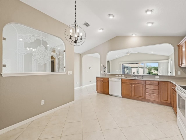 kitchen with vaulted ceiling, white appliances, sink, and light tile patterned floors