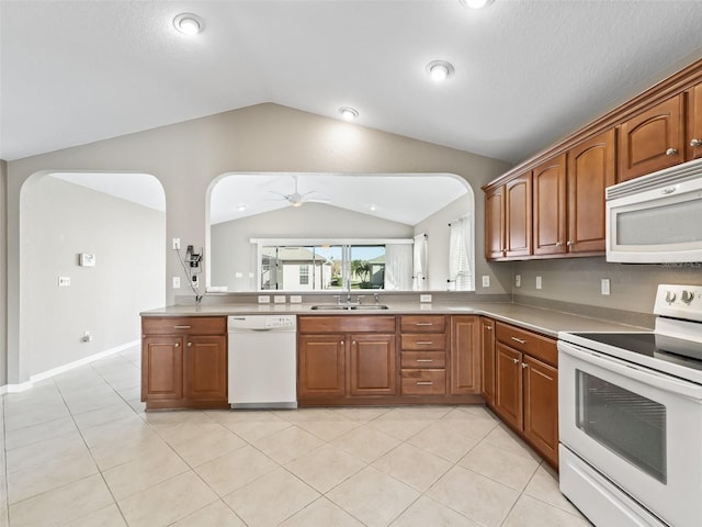 kitchen featuring lofted ceiling, ceiling fan, kitchen peninsula, sink, and white appliances