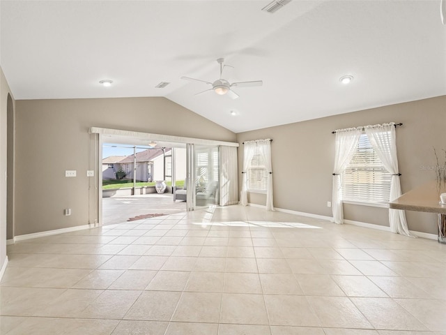 spare room featuring light tile patterned floors, vaulted ceiling, and plenty of natural light