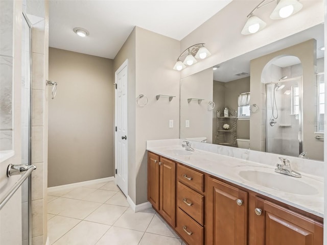 bathroom featuring toilet, tile patterned floors, vanity, and a shower with shower door