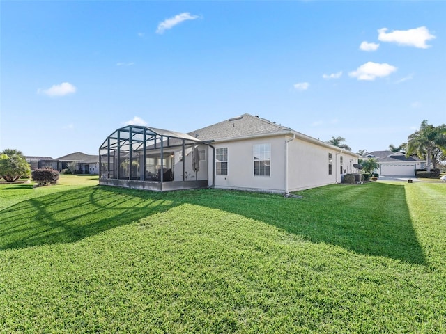 rear view of property featuring a lanai, a yard, and a garage