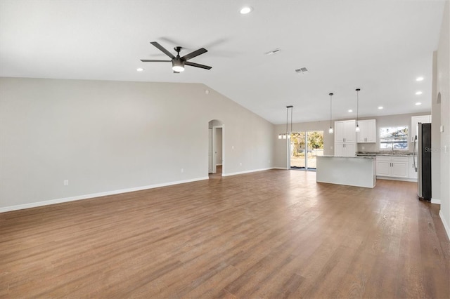 unfurnished living room with ceiling fan, light hardwood / wood-style flooring, and lofted ceiling