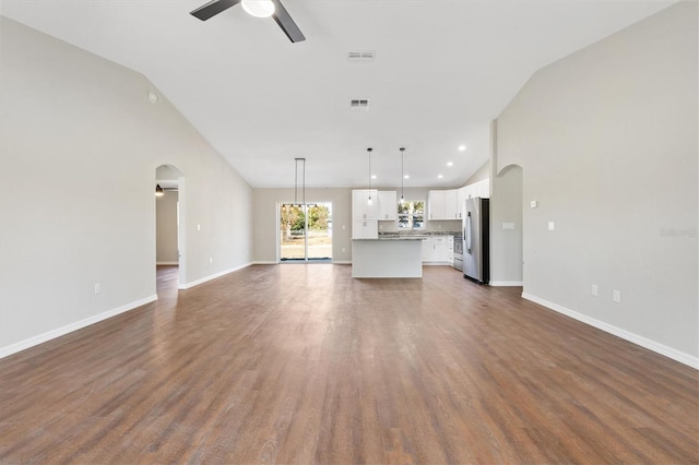 unfurnished living room featuring ceiling fan, dark wood-type flooring, and vaulted ceiling