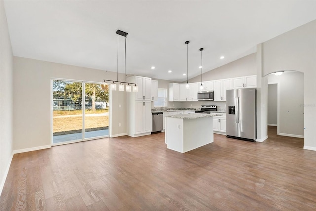 kitchen featuring stainless steel appliances, pendant lighting, white cabinets, and a center island