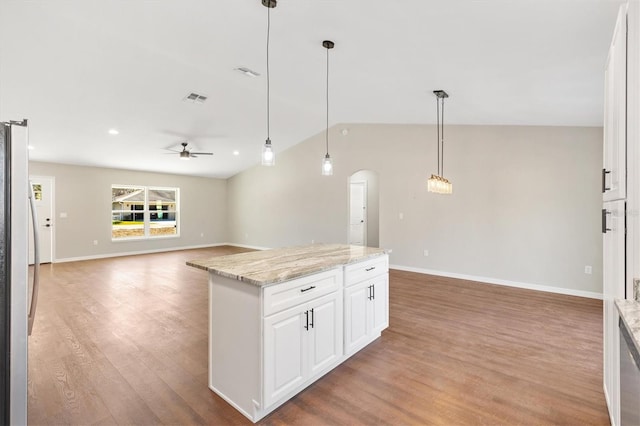 kitchen featuring ceiling fan, light stone countertops, hanging light fixtures, and white cabinets