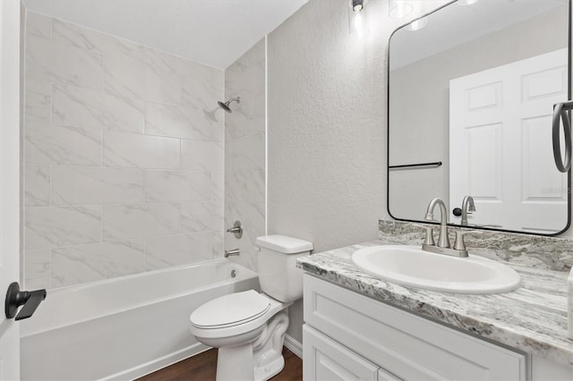 full bathroom with toilet, tiled shower / bath combo, wood-type flooring, and vanity