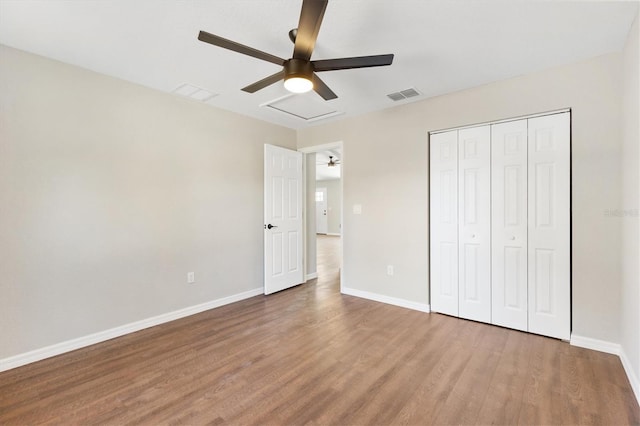 unfurnished bedroom with ceiling fan, hardwood / wood-style flooring, and a closet