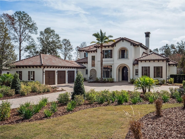 mediterranean / spanish-style home featuring a garage and a front yard