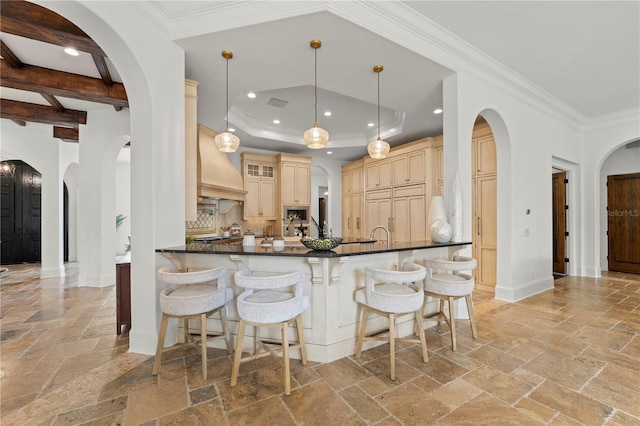 kitchen with paneled built in refrigerator, premium range hood, decorative light fixtures, light brown cabinets, and kitchen peninsula