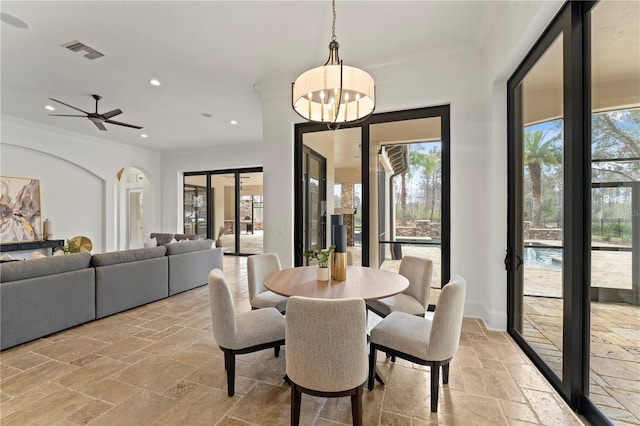 dining room with ceiling fan with notable chandelier and crown molding