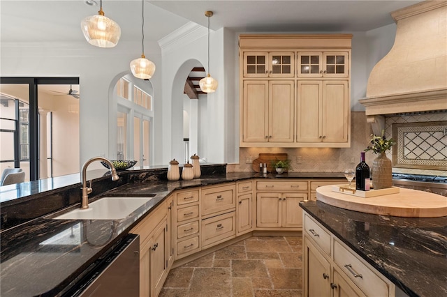 kitchen featuring sink, custom exhaust hood, crown molding, and hanging light fixtures