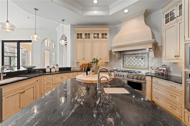 kitchen featuring sink, stainless steel appliances, pendant lighting, and custom range hood