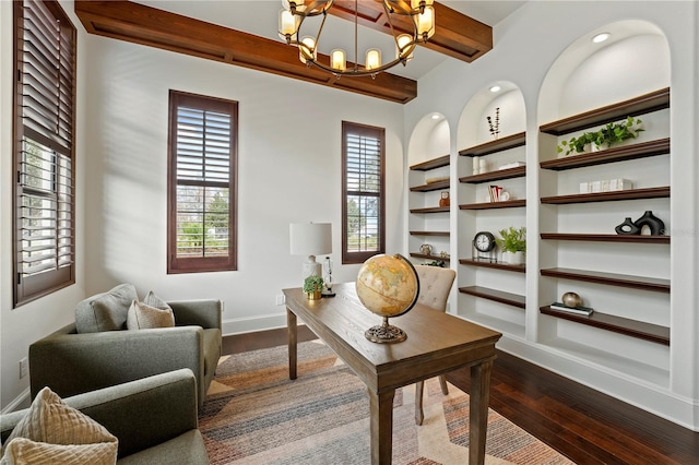 office space featuring beam ceiling, dark hardwood / wood-style floors, built in shelves, and an inviting chandelier