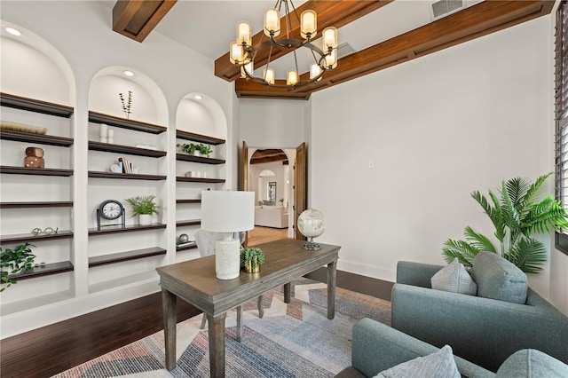 office with built in features, hardwood / wood-style floors, beamed ceiling, and an inviting chandelier