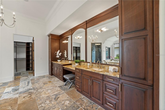 bathroom with a notable chandelier, crown molding, and vanity