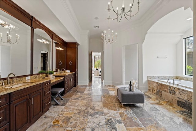 bathroom with tiled tub, vanity, a notable chandelier, and ornamental molding