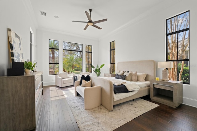 bedroom featuring ceiling fan, ornamental molding, and dark hardwood / wood-style floors