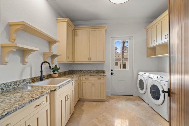 laundry area with sink, crown molding, washer and clothes dryer, and cabinets