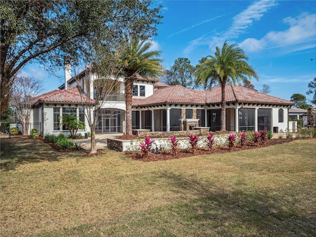 back of house featuring a lawn and a sunroom