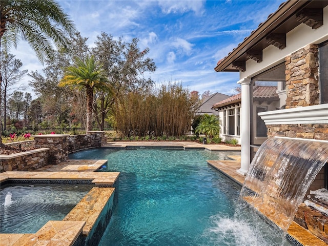 view of pool featuring pool water feature and an in ground hot tub