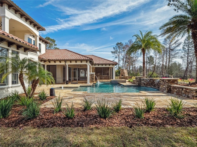 view of swimming pool with pool water feature, a patio, and a sunroom