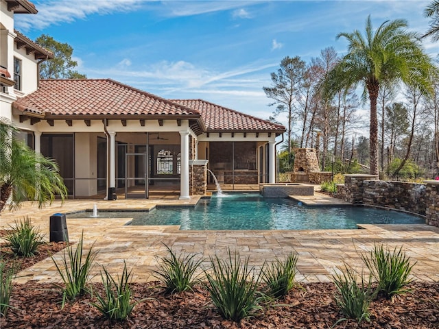 view of swimming pool featuring ceiling fan, pool water feature, a patio, and a sunroom