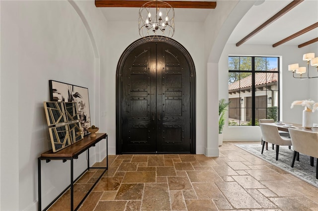 foyer with beamed ceiling and an inviting chandelier