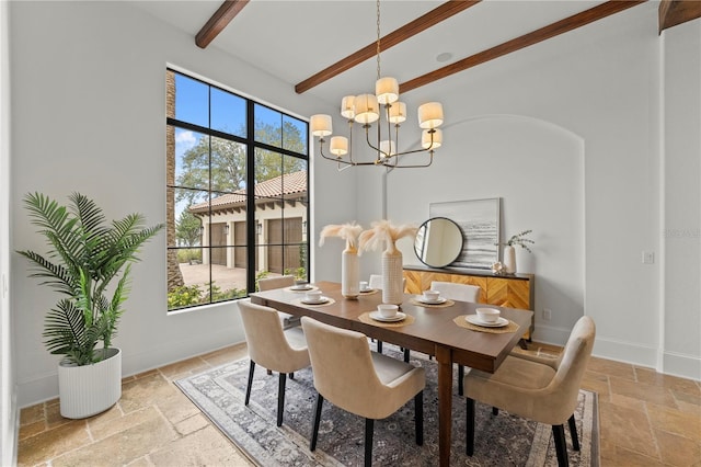 dining space with beam ceiling, a towering ceiling, an inviting chandelier, and a wealth of natural light