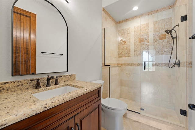 bathroom featuring toilet, vanity, and walk in shower