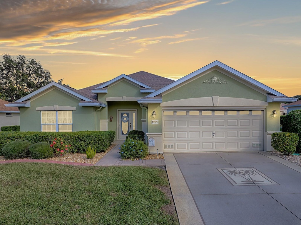 single story home with a garage and a yard