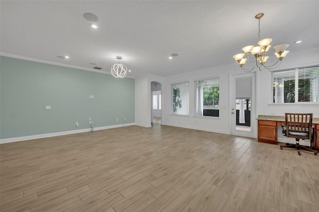 unfurnished living room with light hardwood / wood-style floors, an inviting chandelier, and a healthy amount of sunlight