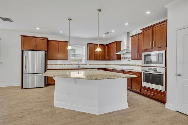 kitchen with stainless steel appliances, light stone counters, a kitchen island, wall chimney range hood, and tasteful backsplash