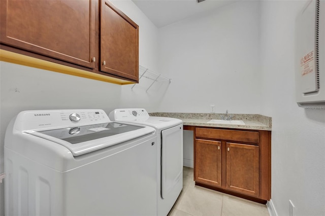 laundry room with sink, cabinets, washer and clothes dryer, and light tile patterned floors