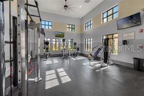 gym with a towering ceiling and ceiling fan