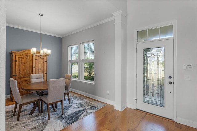 dining space featuring hardwood / wood-style flooring, crown molding, and a chandelier